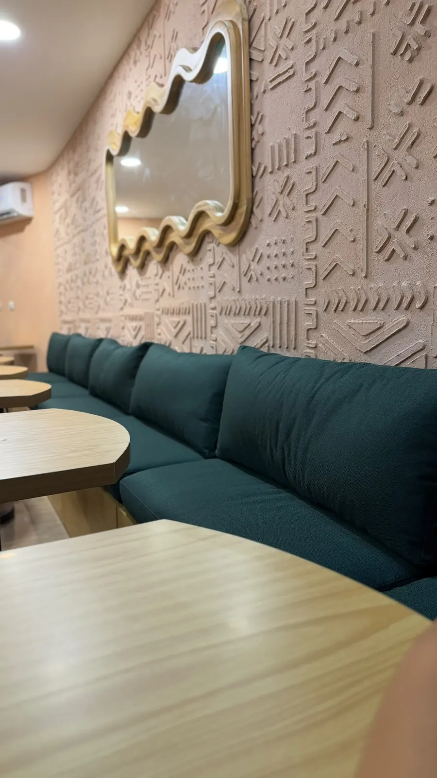 Banquette and gold mirror in the Healthy & Co dining room